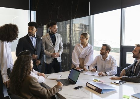 Gestão Empresarial Integrada - Homens e mulheres em uma sala de reunião conversando